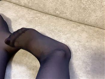 Girl in black nylon tights caresses her long legs